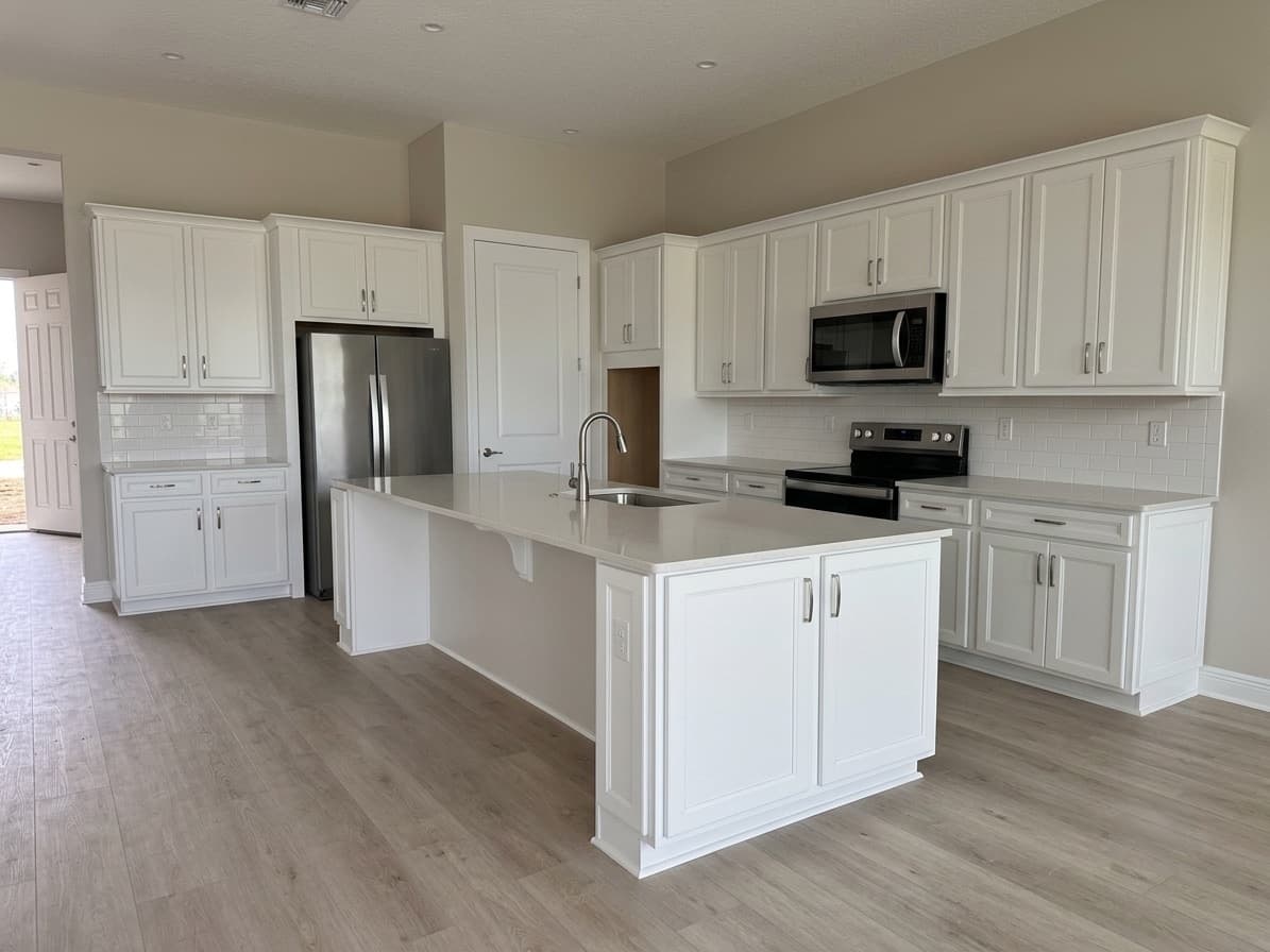 White Shaker Kitchen, Wildwood, FL. White shaker, quartz island, subway backsplash. Full run, sink base to crown.