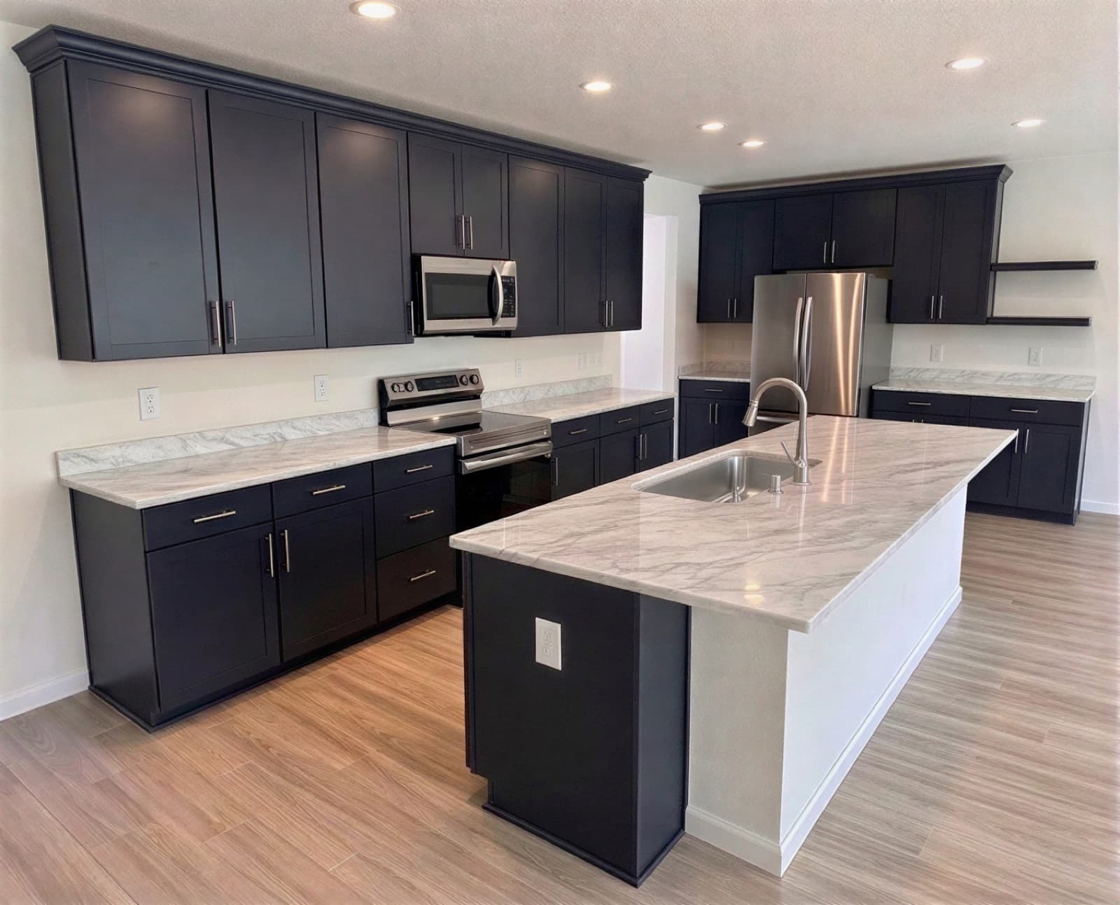 Navy Shaker Kitchen, Marion Oaks, FL. Navy shaker, marbled quartz through the perimeter and island.