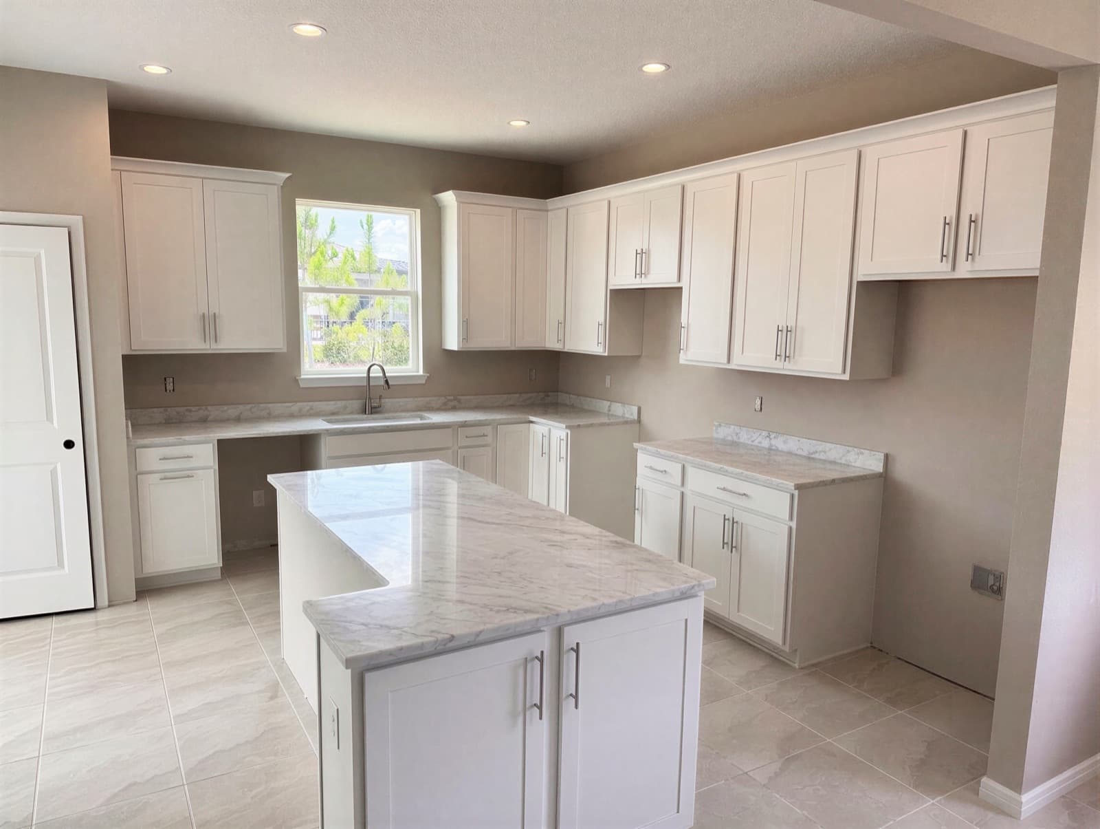 White Shaker Kitchen · L-Island, Ocala, FL. White shaker, marbled quartz, L-island and a built-in desk nook.